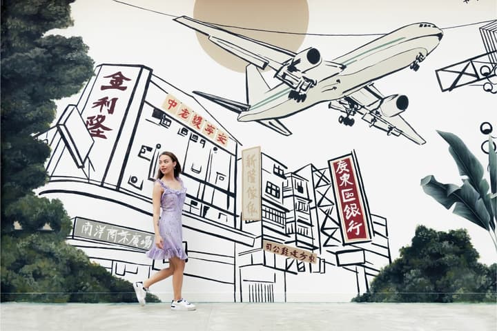 A young woman walking in front of a large mural depicting a commercial airplane flying low over older Hong Kong buildings, symbolizing the city's Kowloon Walled City and Kai Tak history.