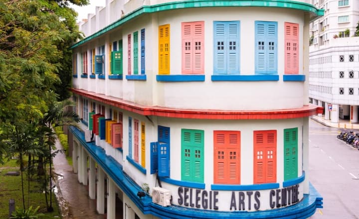 Historic Selegie Arts Centre building exterior, known for its distinctive architecture and colorful window shutters in red, yellow, green, and blue.