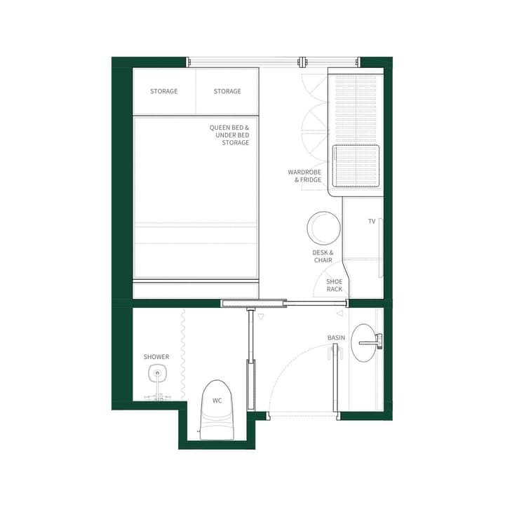 Floor plan for a Studio Queen unit, showing a queen bed with under-bed storage, a desk, a wardrobe/fridge unit, and a bathroom with a shower and WC. This layout features a full wall of additional storage above the bed.