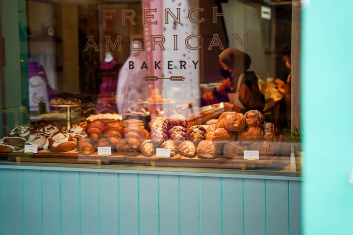 Close-up of a pastry display window at a French American Bakery, showcasing an array of fresh croissants and baked goods.
