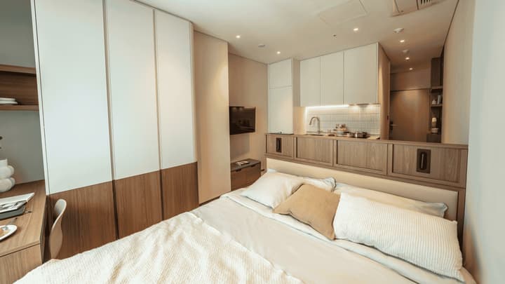 Detailed view of the Queen Suite focusing on the excellent storage, including the large floor-to-ceiling two-tone wardrobe on the left and the fully built-in kitchenette on the right.