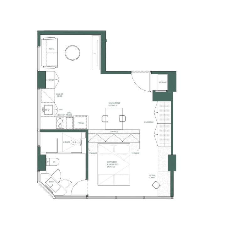Top-down floor plan layout of a one-bedroom apartment suite showing an open-concept design with a queen bed, a desk, a full kitchen with a washer/dryer unit, a separate living area with a sofa, and a three-piece bathroom.