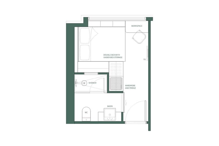 Top-down floor plan layout of a WSKT Studio Double apartment, showing a double bed with under-bed storage, a separate workspace desk, a wardrobe/fridge unit, and a private ensuite bathroom with a toilet, sink, and shower.
