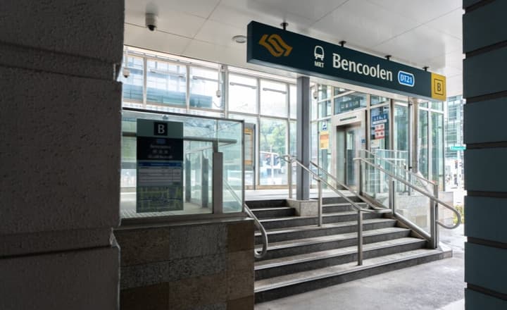 Bencoolen MRT station entrance showing a set of steps, glass panels, and the overhead DT21 station signage.