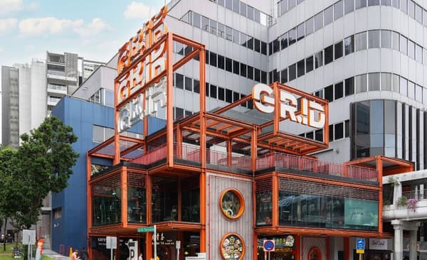 The GR.iD retail building with its distinctive modern architecture and prominent orange metal structure and glass facade.
