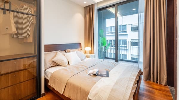Contemporary bedroom with wood floors, a double bed, a glass-front closet, and a large sliding glass door opening to a balcony.