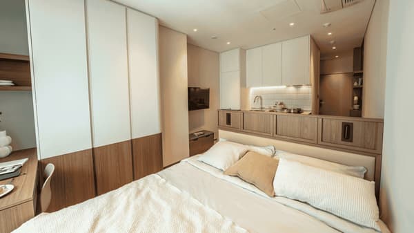 Detailed view of the Queen Suite focusing on the excellent storage, including the large floor-to-ceiling two-tone wardrobe on the left and the fully built-in kitchenette on the right.